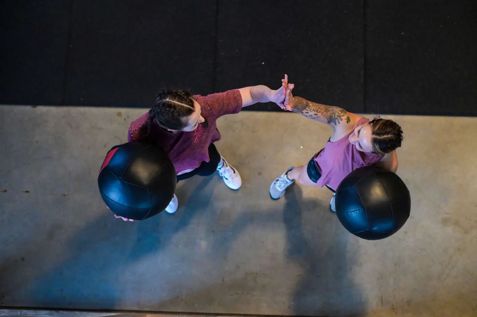 Zwei Athletinnen klatschen beim Wall Ball Workout ab in der Halle Zwo Badem